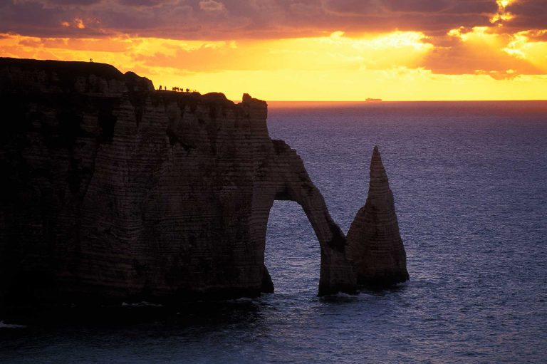 De kliffen Falaise d'Aval en l'Aiguille bij Etretat bij zonsondergang.