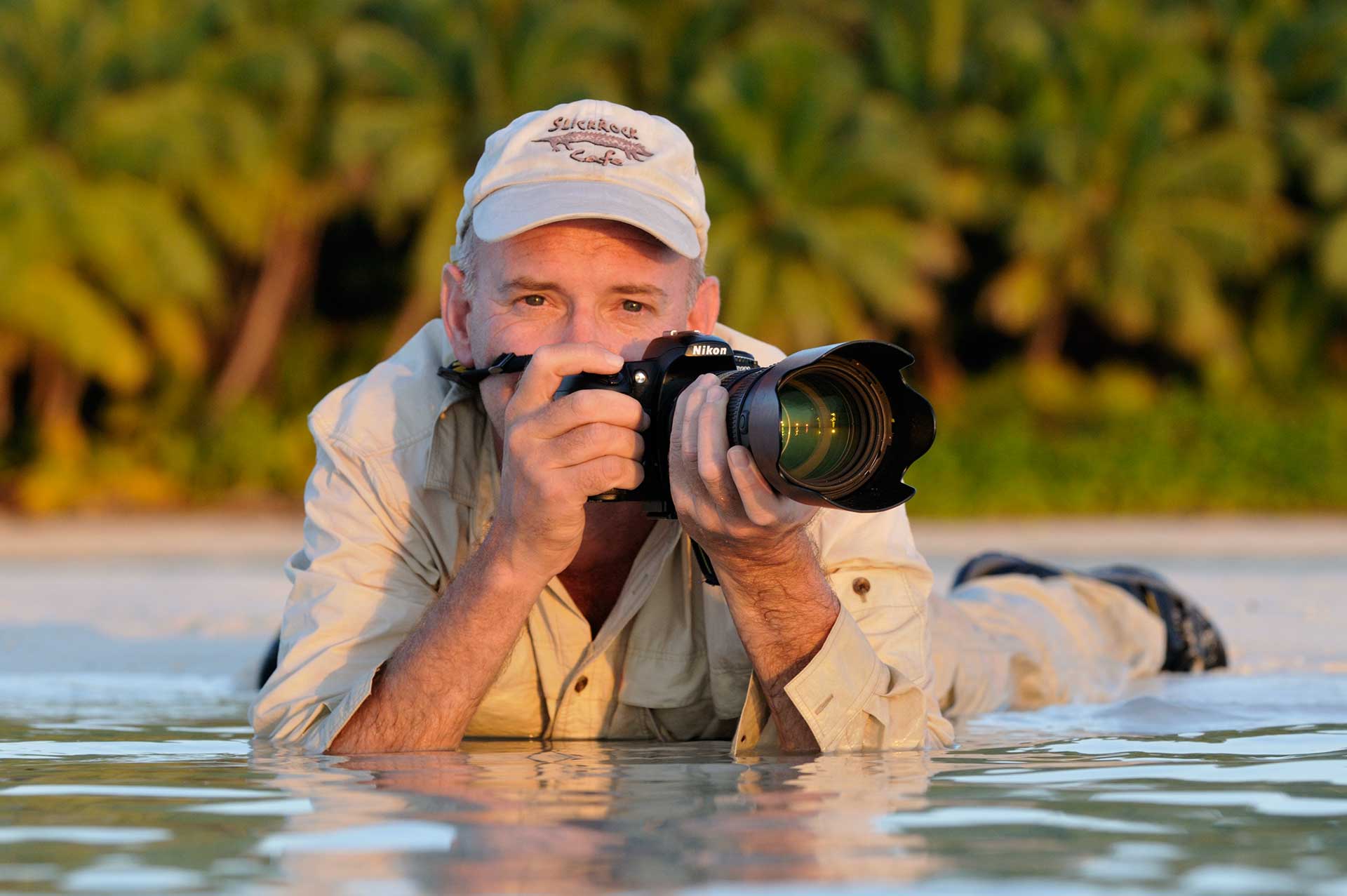 Martin van Lokven aan het werk op de Seychellen, fotograferend in water.