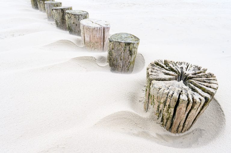 Strandpalen met opgestoven zand